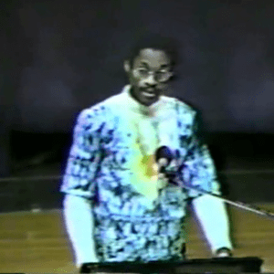 A man in a suit is speaking at a podium.