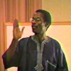 A man in glasses is holding up his hand.